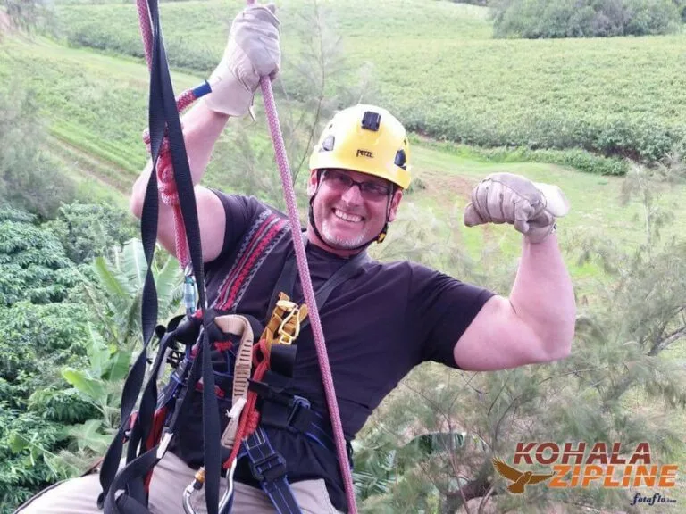 Dr. Brent Wells posing while climbing a large boulder.