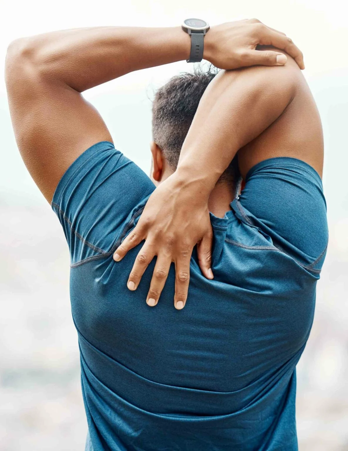 A fit man stretching his shoulder.