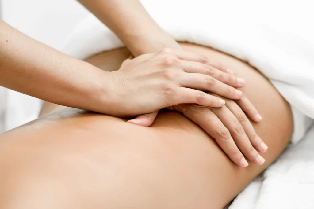 A chiropractor doing massage to a patient's lower back.