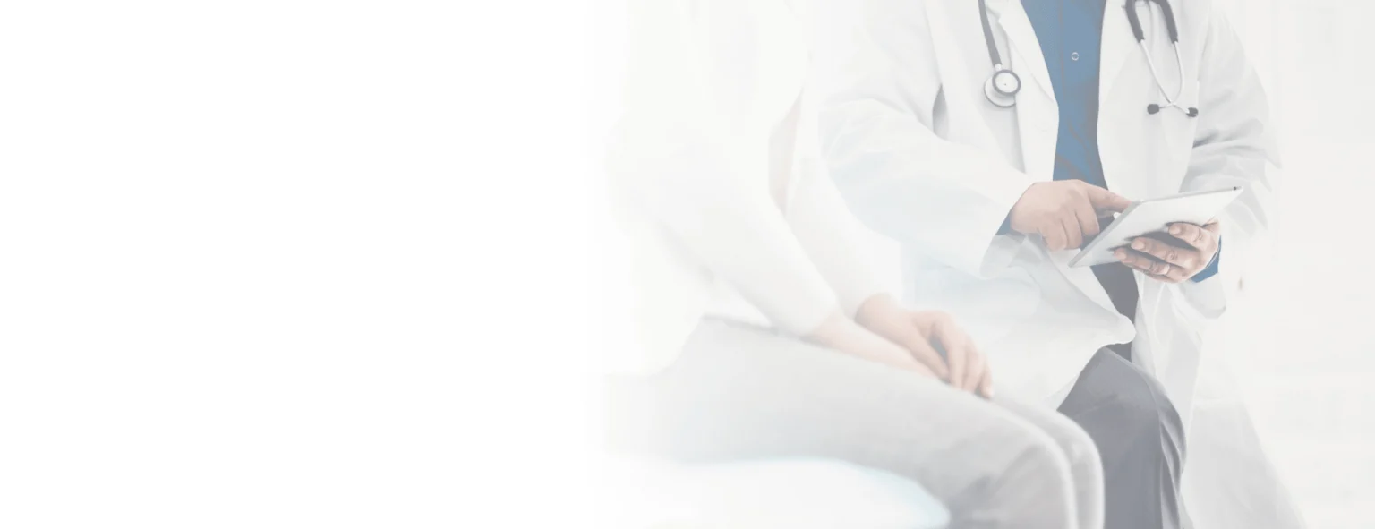 A doctor next to a patient scrolling through something on a tablet.