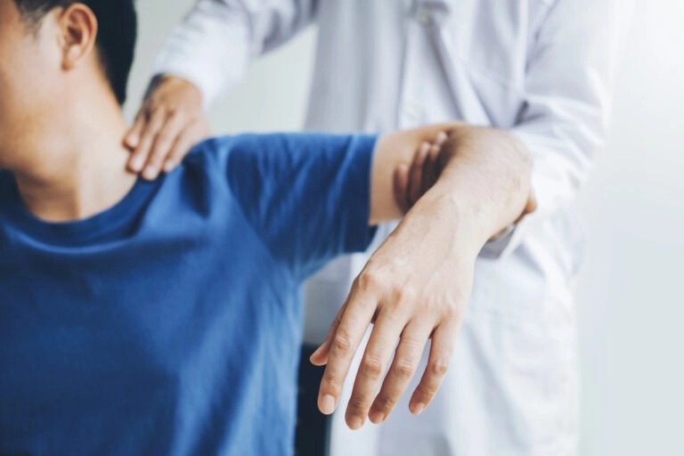 A man having his shoulder checked by a chiropractor.