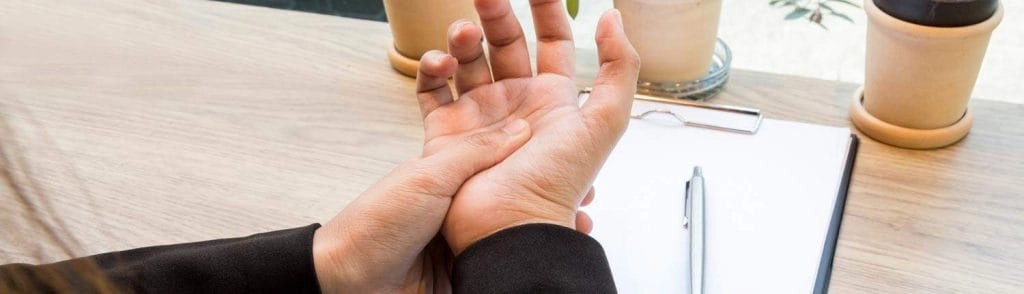 A woman pressing the palm of her hand with her thumb.