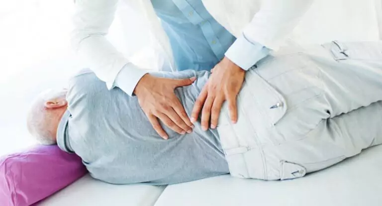 A man getting treatment in his lower back by a chiropractor.