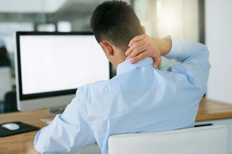 A man touching his neck in pain.