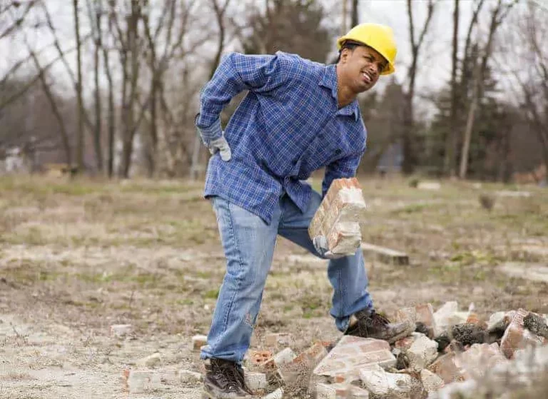 A man trying to do construction work and feeling pain.