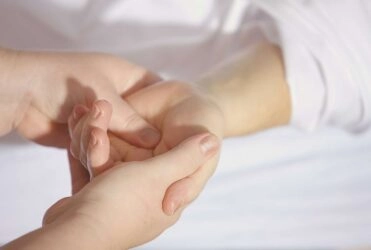 A woman getting a massage on the palm of her hand.