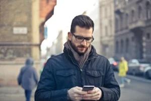 A man using his cellphone in a city.