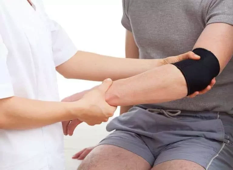 A man getting his arm treated by a chiropractor.